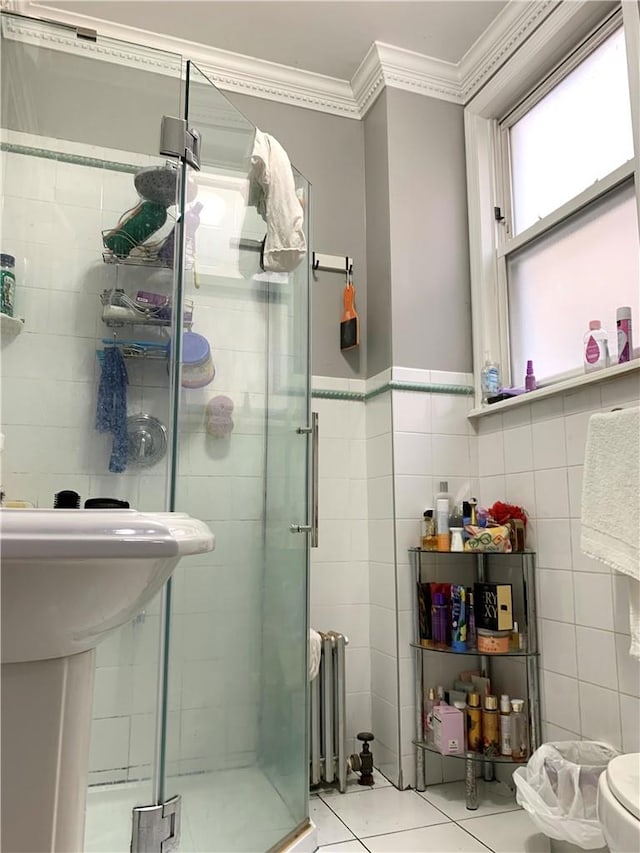 bathroom featuring tile patterned floors, ornamental molding, tile walls, walk in shower, and radiator heating unit