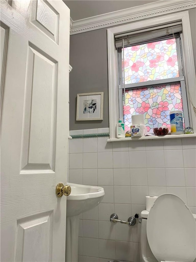 bathroom featuring toilet and tile walls