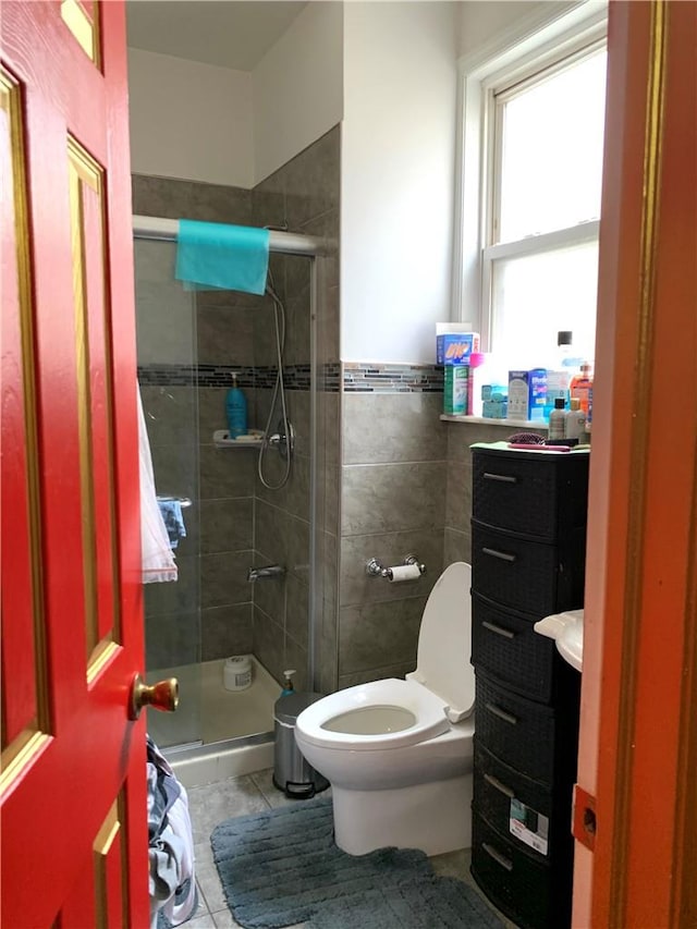 bathroom with tile patterned floors, toilet, and an enclosed shower