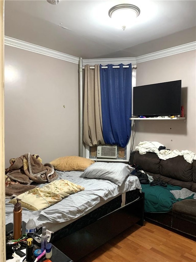 bedroom with hardwood / wood-style flooring, cooling unit, and ornamental molding