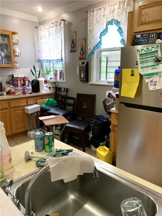 kitchen with stainless steel refrigerator, light tile patterned flooring, and ornamental molding