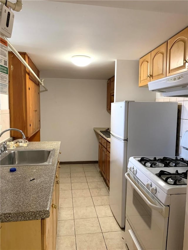 kitchen with light tile patterned floors, gas range gas stove, and sink