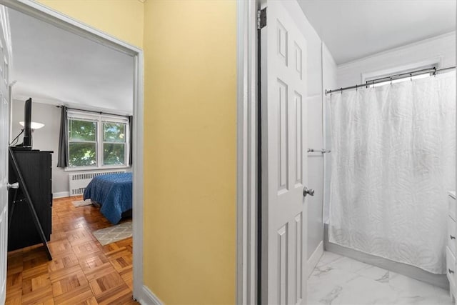 bathroom featuring radiator heating unit, shower / bath combo, and parquet flooring