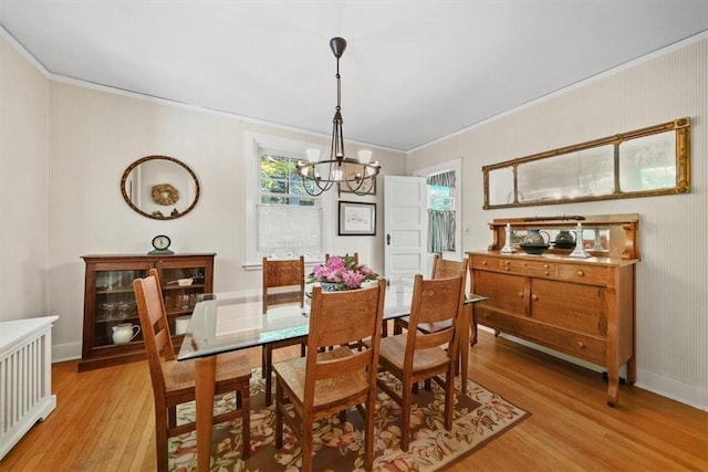 dining room featuring light hardwood / wood-style floors, an inviting chandelier, and crown molding