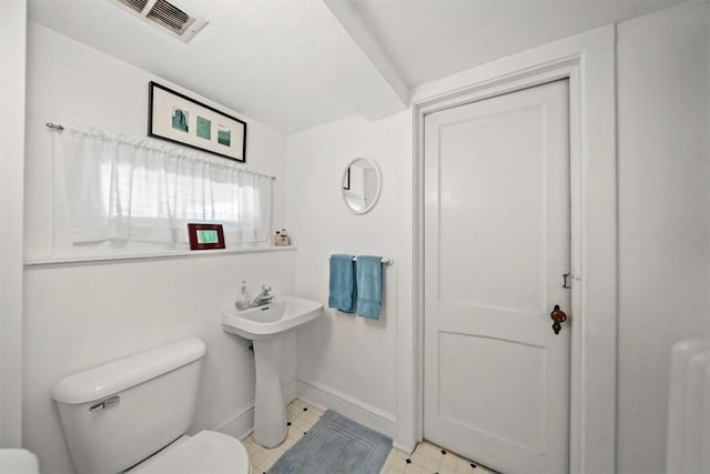 bathroom featuring radiator heating unit, toilet, and sink