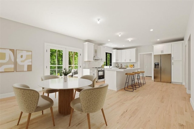 dining area featuring french doors, sink, and light wood-type flooring