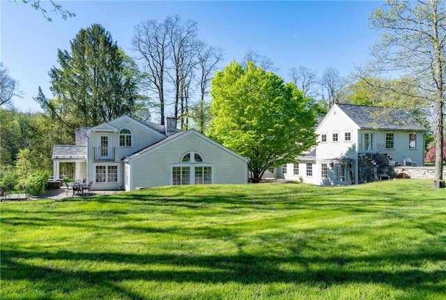 back of property with a lawn and a patio area