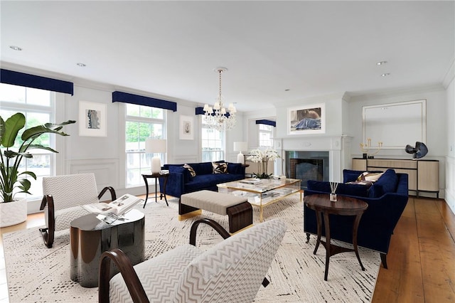 living room with an inviting chandelier, ornamental molding, and light hardwood / wood-style flooring