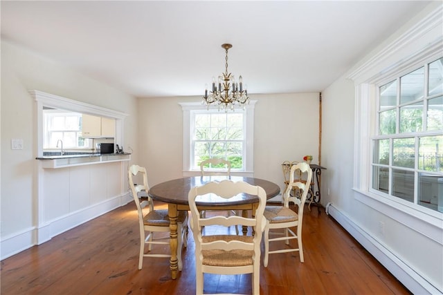 dining area with a notable chandelier, plenty of natural light, dark hardwood / wood-style flooring, and a baseboard radiator