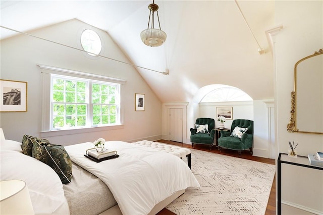 bedroom with hardwood / wood-style floors and lofted ceiling