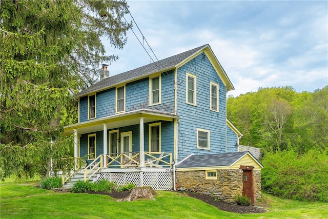 view of front of house featuring covered porch and a front yard