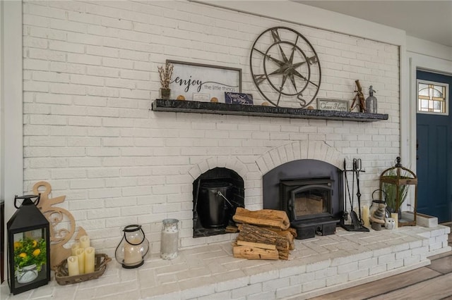 room details with hardwood / wood-style flooring and a wood stove