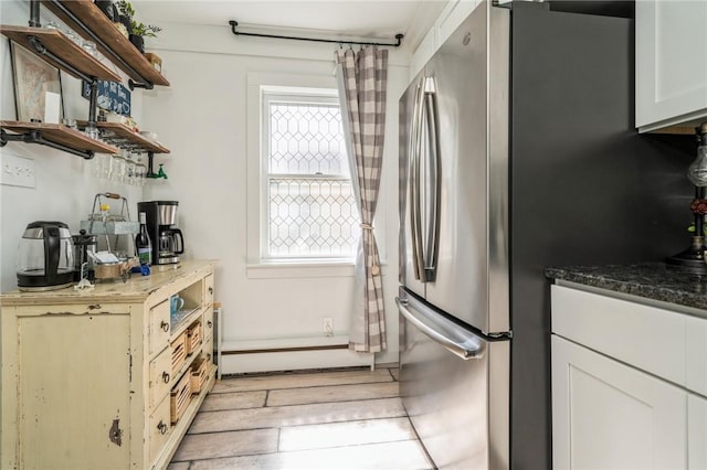 kitchen with stainless steel refrigerator and white cabinets