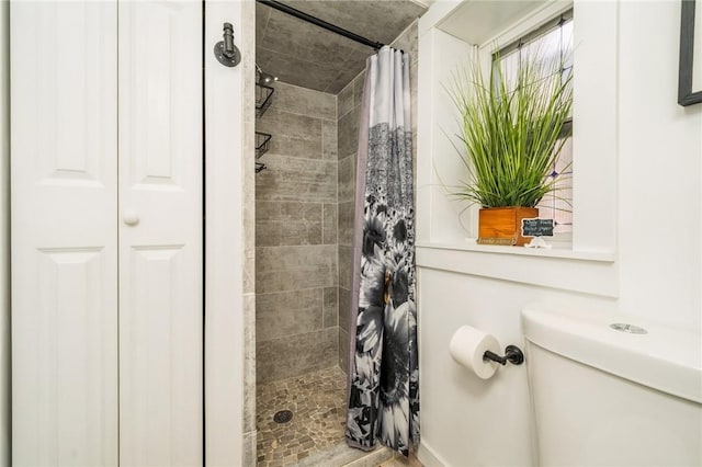 bathroom with curtained shower and toilet