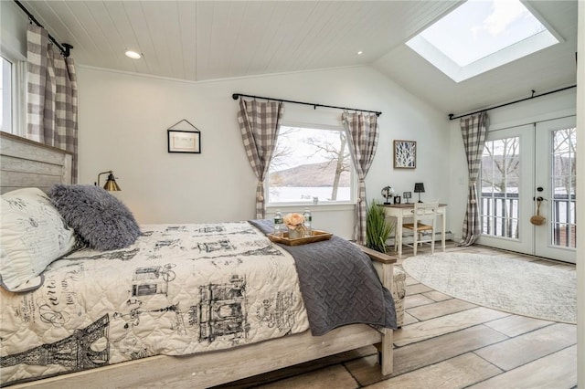 bedroom featuring access to exterior, french doors, wood ceiling, vaulted ceiling with skylight, and hardwood / wood-style flooring