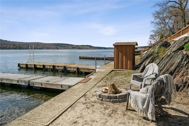 view of dock with a water view and an outdoor fire pit