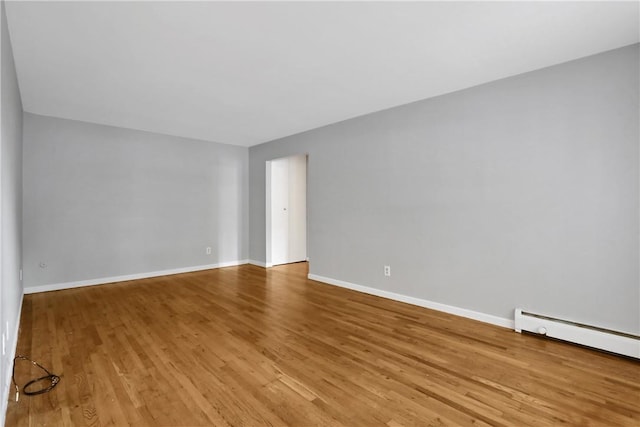 spare room with light wood-type flooring and a baseboard radiator