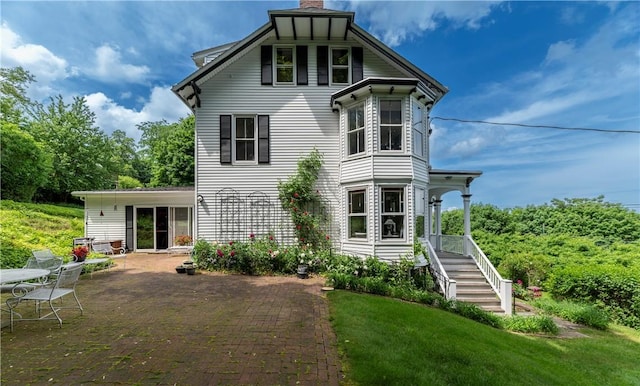 back of property featuring a patio area and a lawn