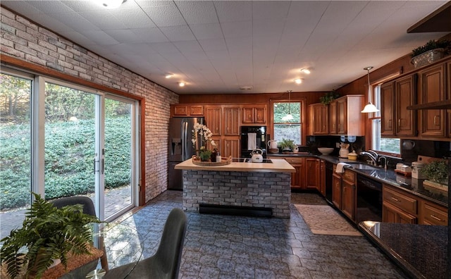 kitchen with a kitchen island, brick wall, decorative light fixtures, sink, and black appliances