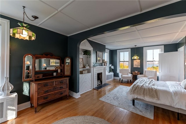 bedroom with coffered ceiling and light hardwood / wood-style flooring