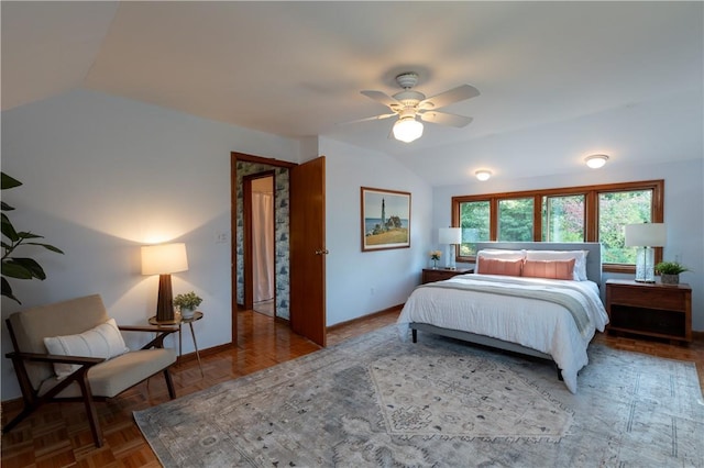 bedroom featuring dark parquet flooring, vaulted ceiling, and ceiling fan