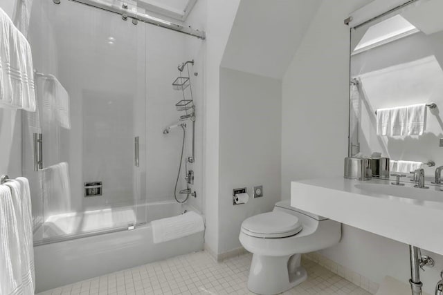 bathroom featuring combined bath / shower with glass door, tile patterned floors, and toilet