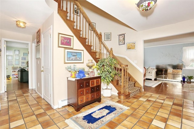 staircase featuring tile patterned floors and a baseboard heating unit