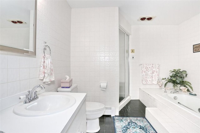 full bathroom featuring tile patterned flooring, a baseboard heating unit, toilet, vanity, and tile walls