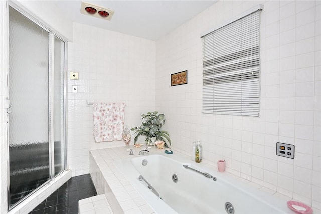 bathroom featuring tiled bath and tile walls