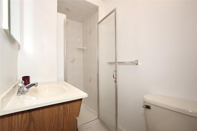 bathroom with vanity, toilet, and a shower with shower door