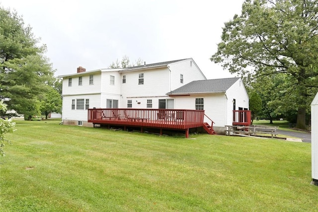 rear view of property featuring a yard and a wooden deck