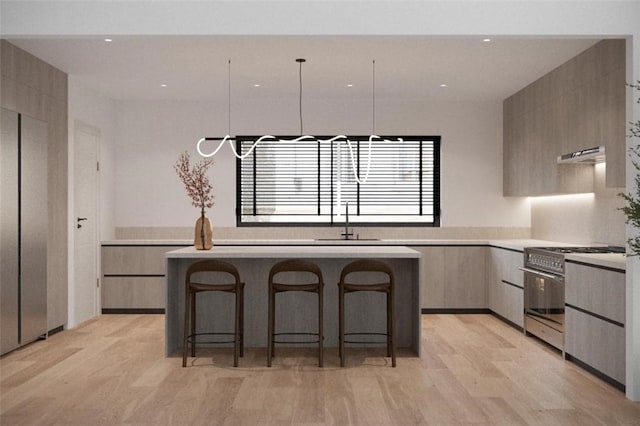 kitchen featuring a breakfast bar area, gas range, and light wood-type flooring