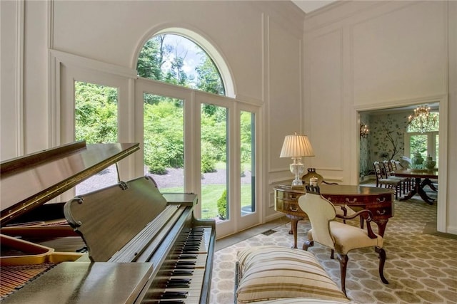 interior space featuring a wealth of natural light, a chandelier, and a high ceiling