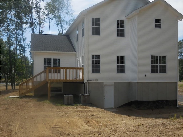 back of house with central AC unit and a wooden deck