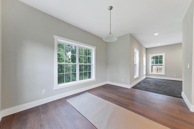 unfurnished dining area with a wealth of natural light and dark hardwood / wood-style floors