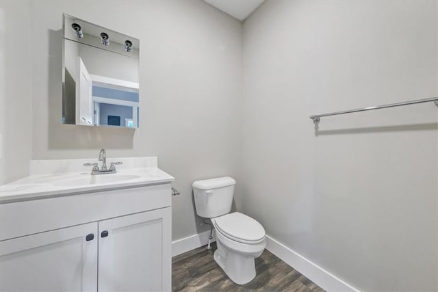 bathroom with hardwood / wood-style flooring, vanity, and toilet