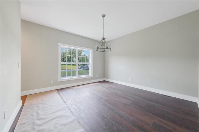 unfurnished dining area featuring hardwood / wood-style floors and an inviting chandelier