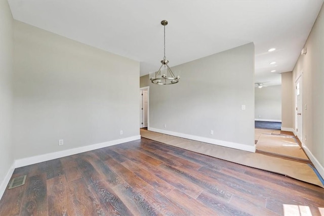 unfurnished room with ceiling fan with notable chandelier and wood-type flooring