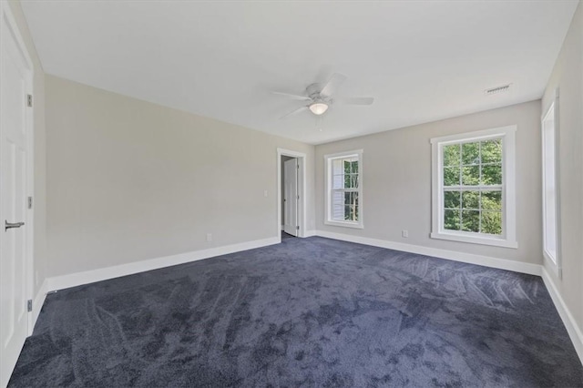 unfurnished bedroom with dark carpet and ceiling fan