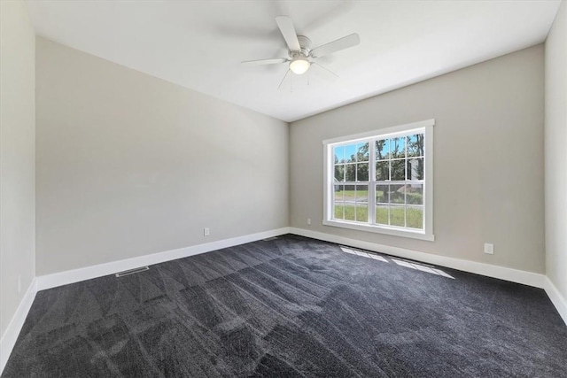 empty room with dark carpet and ceiling fan