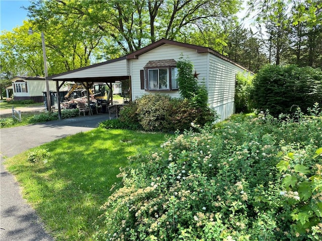 view of property exterior with a yard and a carport