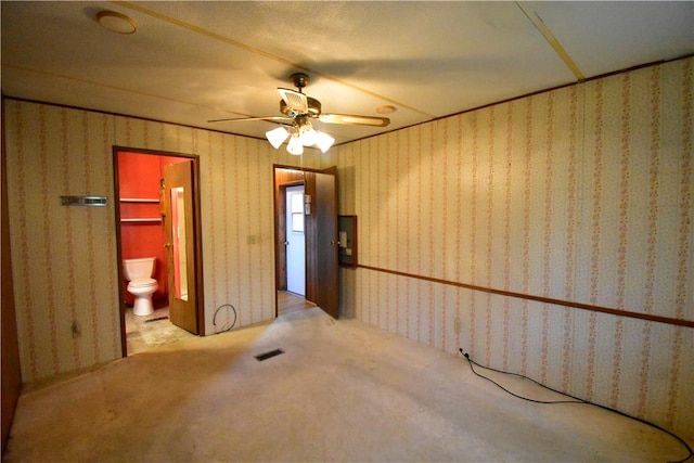 interior space featuring ceiling fan, light carpet, and connected bathroom