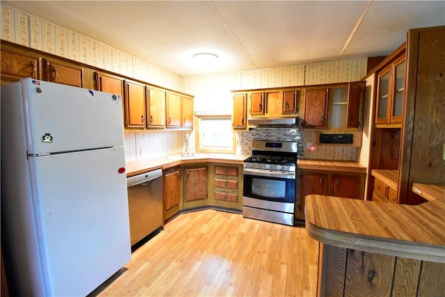 kitchen featuring decorative backsplash, light hardwood / wood-style flooring, and stainless steel appliances