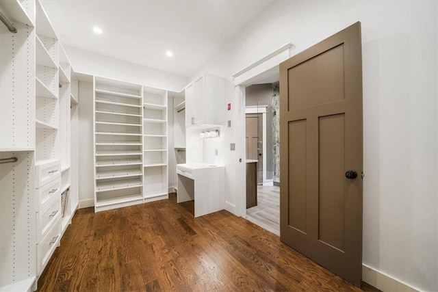 walk in closet with dark wood-type flooring