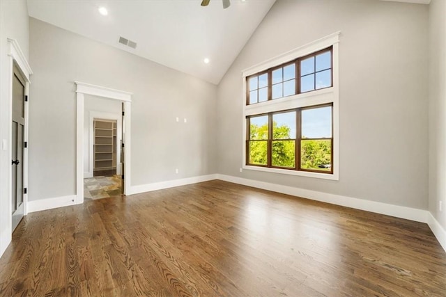 interior space with dark hardwood / wood-style flooring, high vaulted ceiling, and ceiling fan