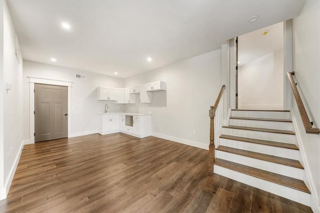 unfurnished living room with sink and dark wood-type flooring