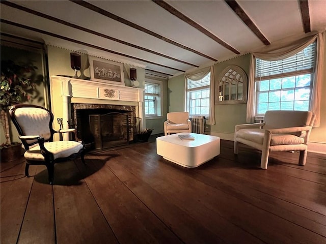 living area featuring hardwood / wood-style floors, a healthy amount of sunlight, and beamed ceiling