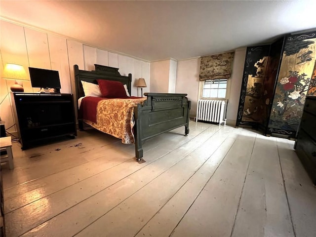 bedroom with radiator heating unit and hardwood / wood-style floors