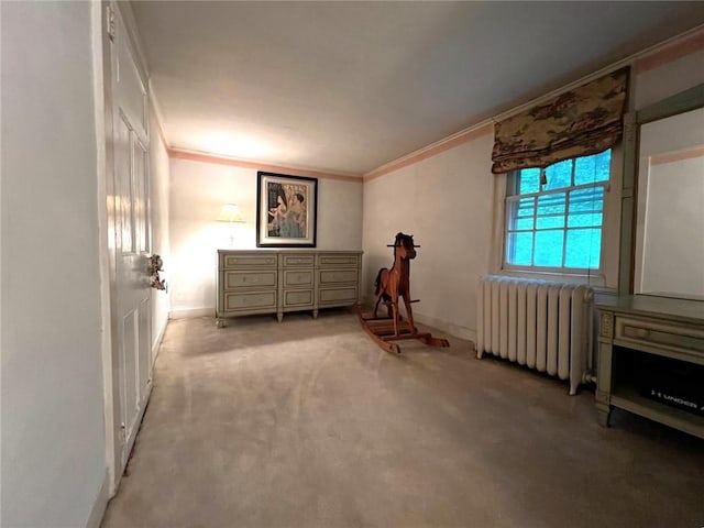 interior space with crown molding, radiator heating unit, and light colored carpet