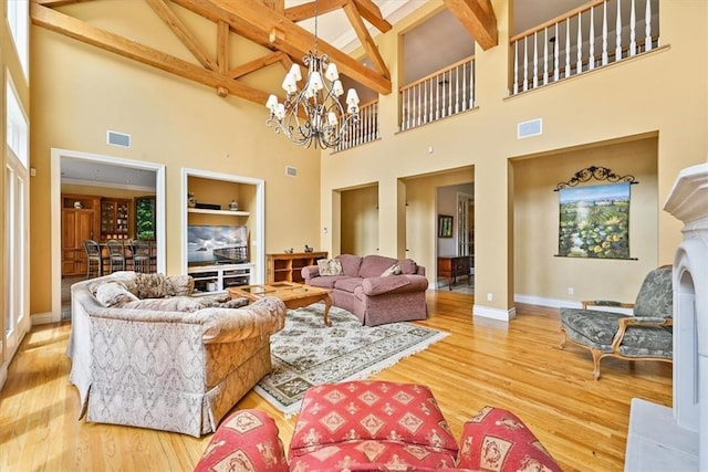 living room featuring beamed ceiling, wood-type flooring, high vaulted ceiling, and an inviting chandelier